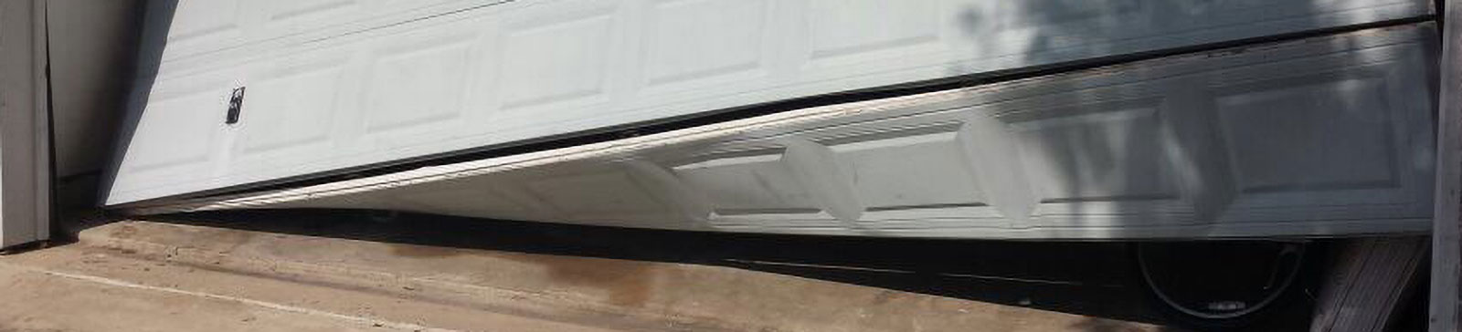 Garage door in Darien, IL visibly off tracks and leaning against the driveway, showing need for repair